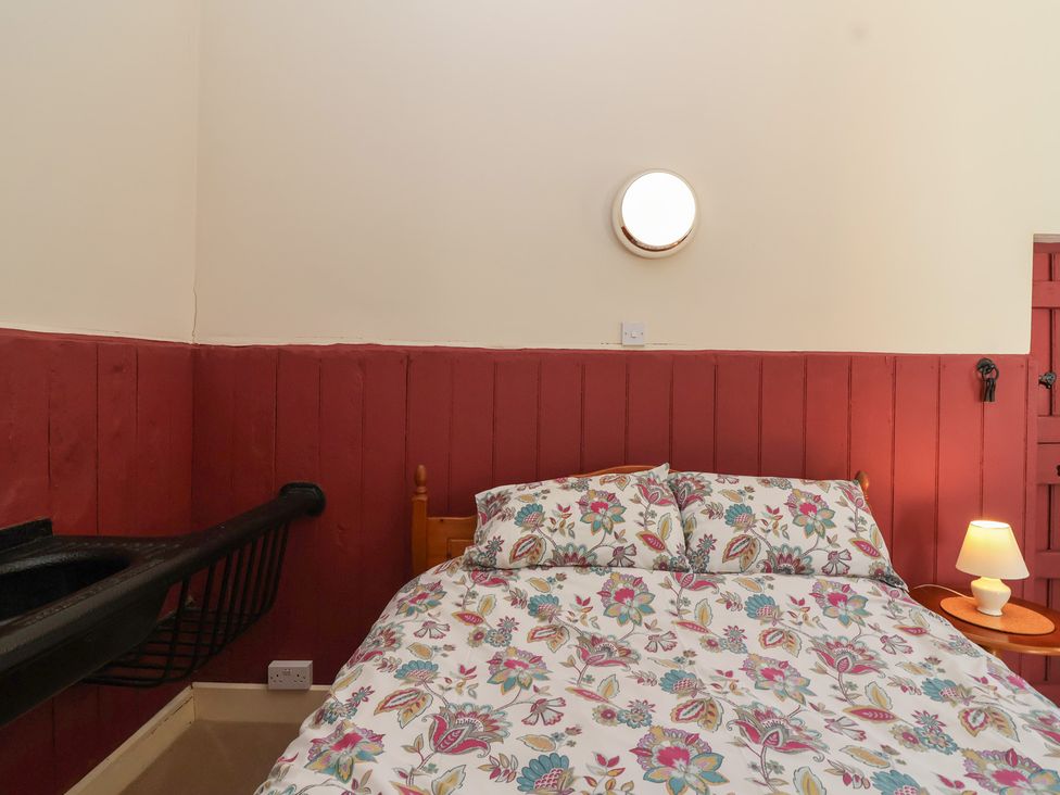 A bedroom with a bed and table at Harness Rooms in Gloucester
