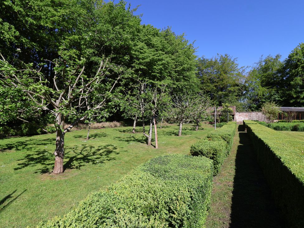 A garden with trees and hedges at Harness Rooms Gloucester
