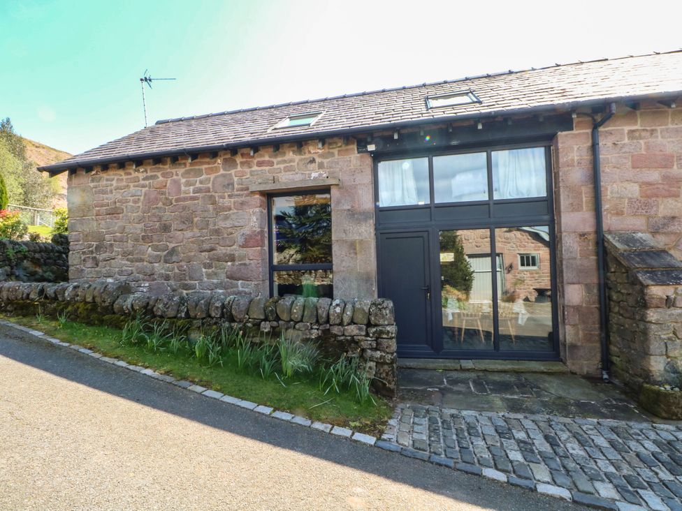An outdoor view of a stone house with a wall and road at Pearls Farm Two Wildboarclough near Macclesfield