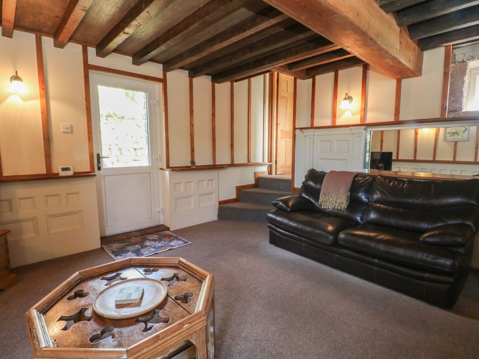 A living room with a sofa and door at Pearls Farm Two in Wildboarclough near Macclesfield