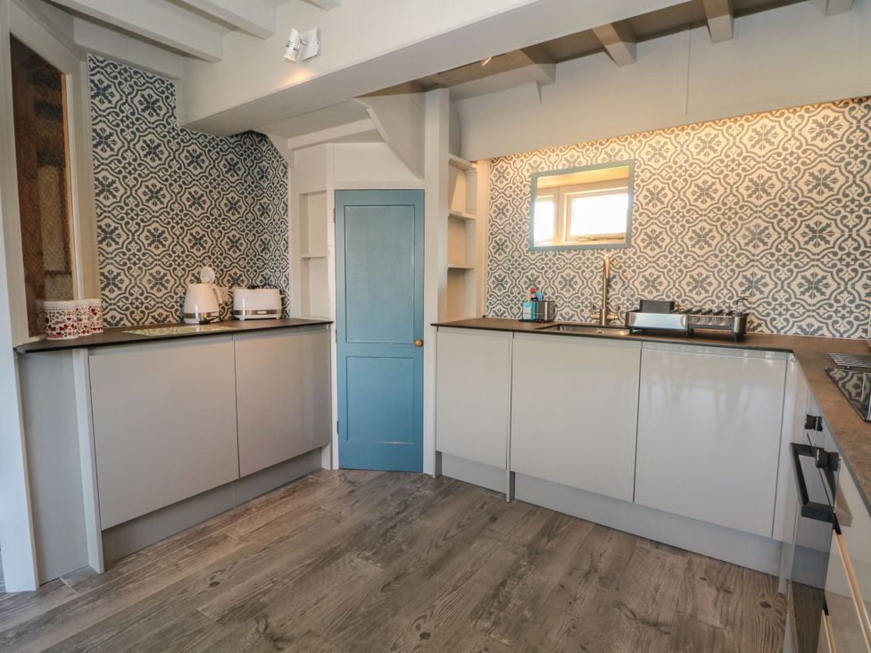 A kitchen with cabinets, a sink, and a mirror at Pearls Farm Two in Wildboarclough near Macclesfield