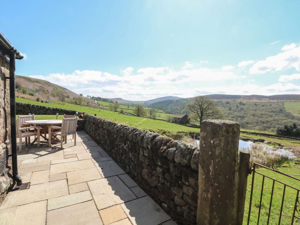 An outdoor patio area with a table and chairs at Pearls Farm Two in Wildboarclough near Macclesfield