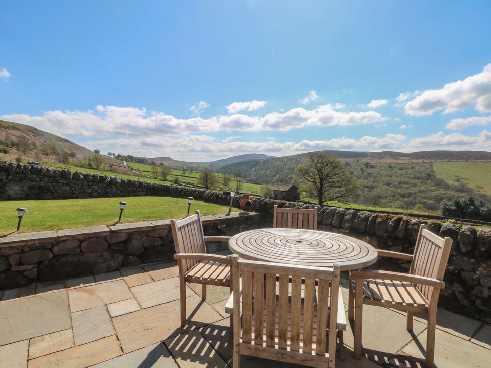 A patio with a table and chairs overlooking mountains at Pearls Farm Two in Wildboarclough near Macclesfield