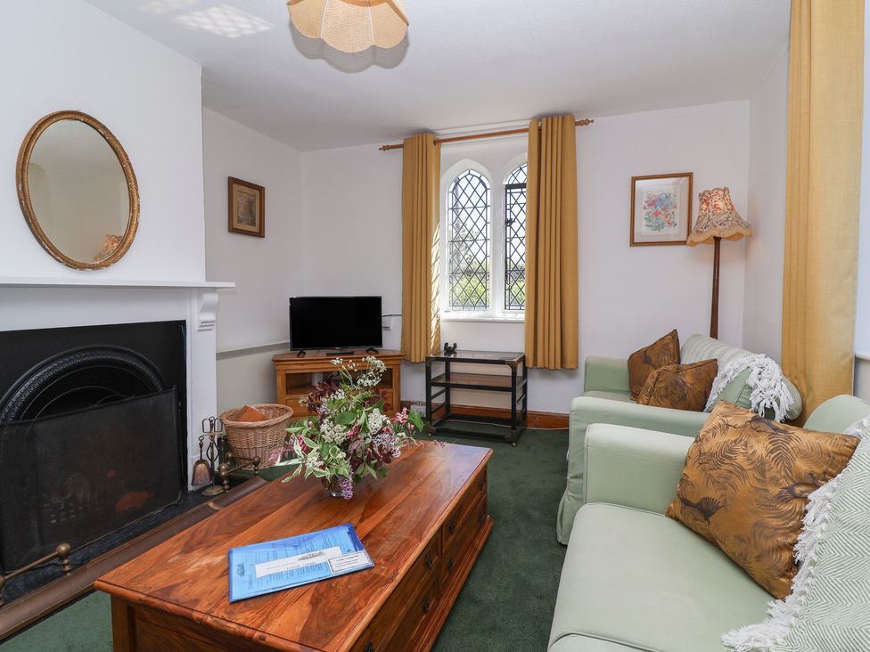 A living room with a television and a fireplace at The Lodge in Gloucester