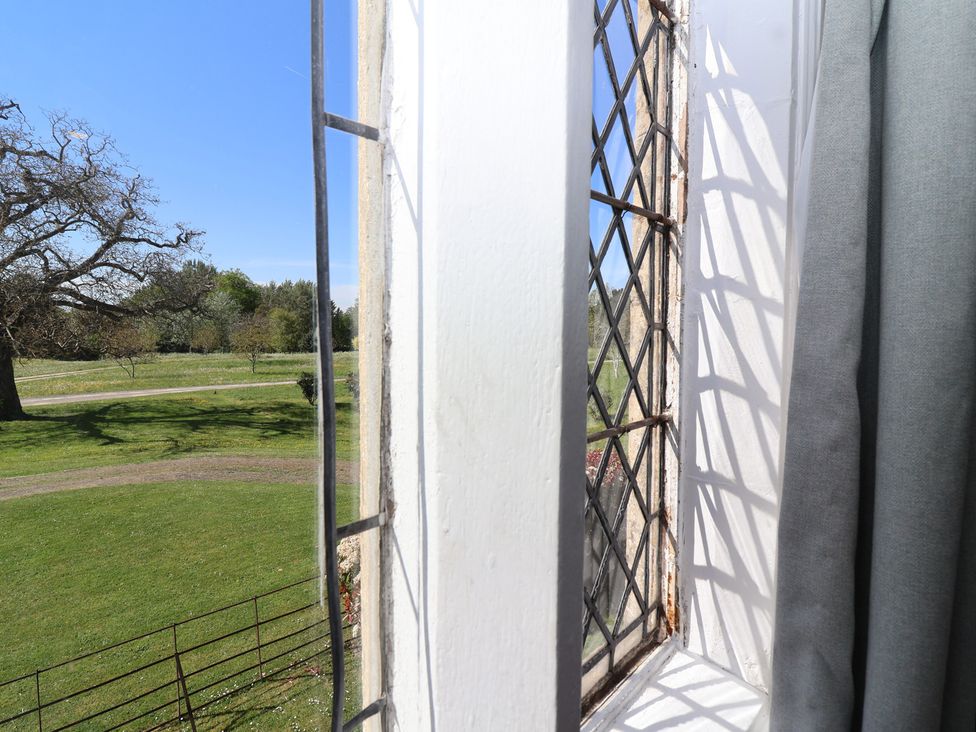 A window view showing trees and grass at The Lodge in Gloucester