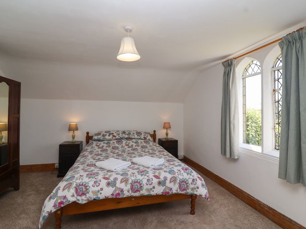 A bedroom with a bed, lamps, and a window at The Lodge in Gloucester