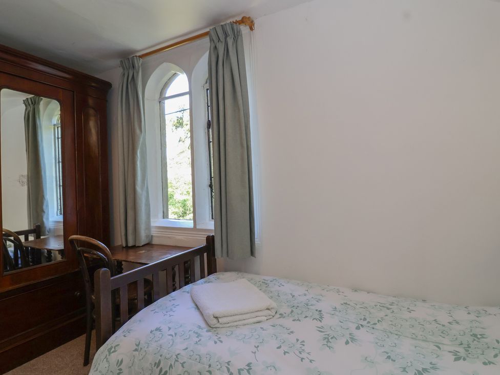 A bedroom with a bed and mirror at The Lodge in Gloucester