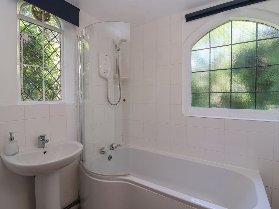 A bathroom with a bath tub, sink and shower at The Lodge in Gloucester