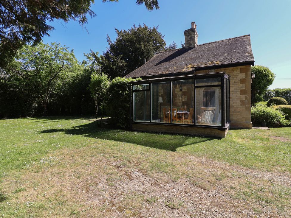 A house with a conservatory in a garden at The Lodge in Gloucester