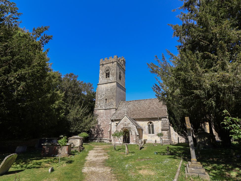 A church with a graveyard and trees at The Lodge in Gloucester