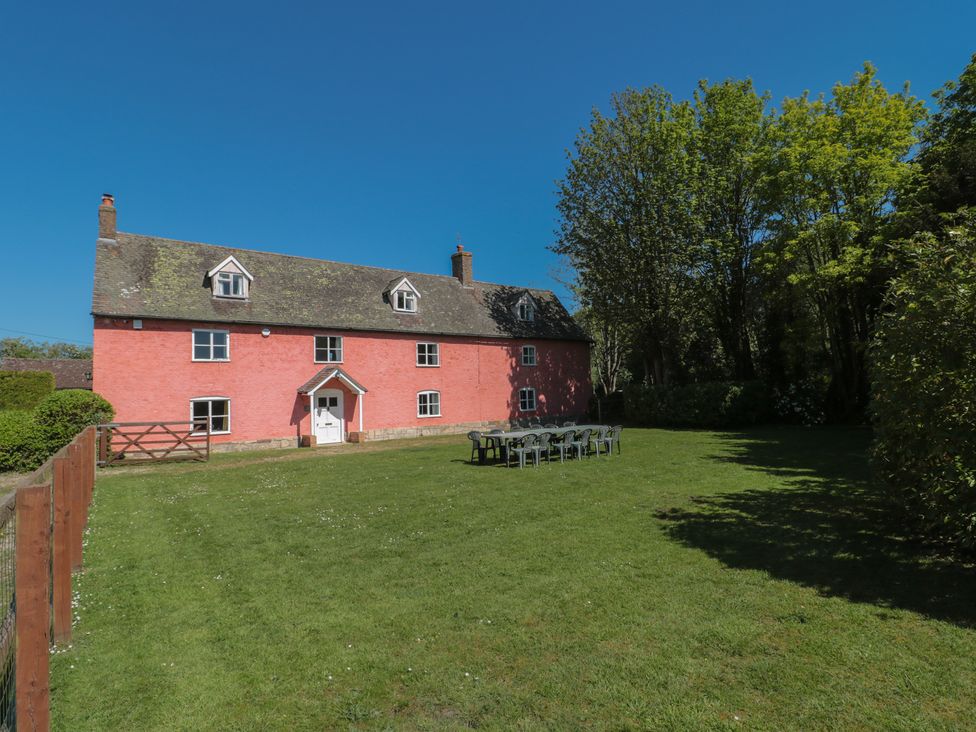 A house with a garden and seating area at Walk Farmhouse in Gloucester