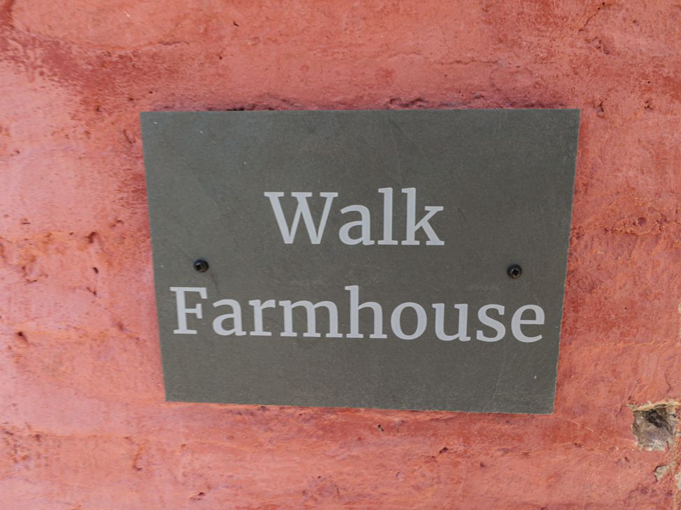 A sign for Walk Farmhouse on a brick wall in Gloucester