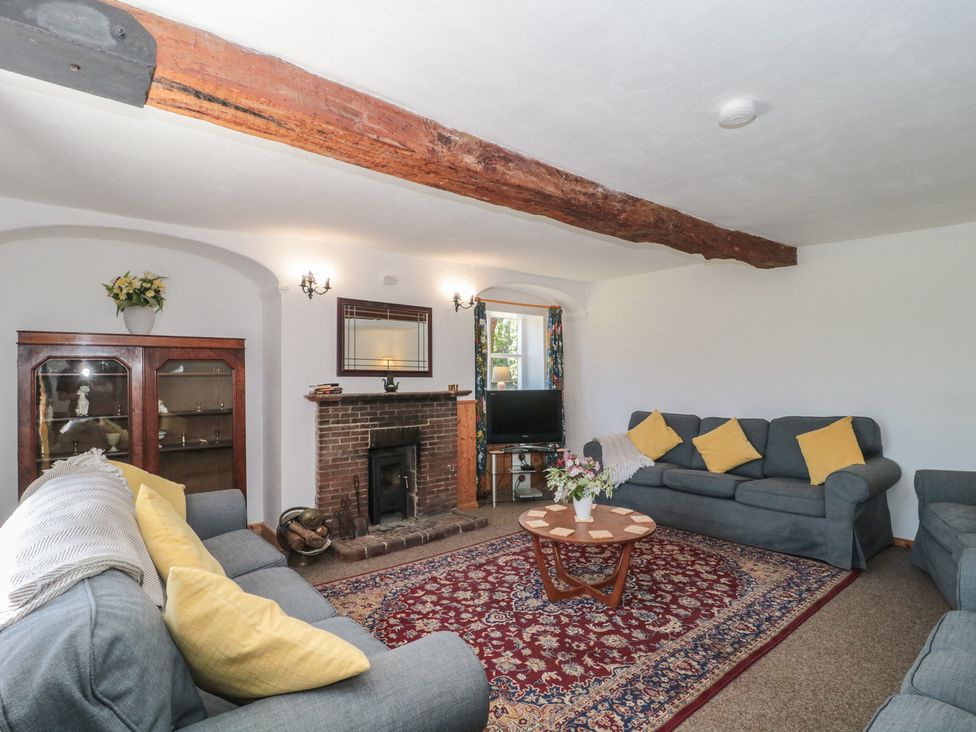 A living room with a fireplace and seating area at Walk Farmhouse in Gloucester