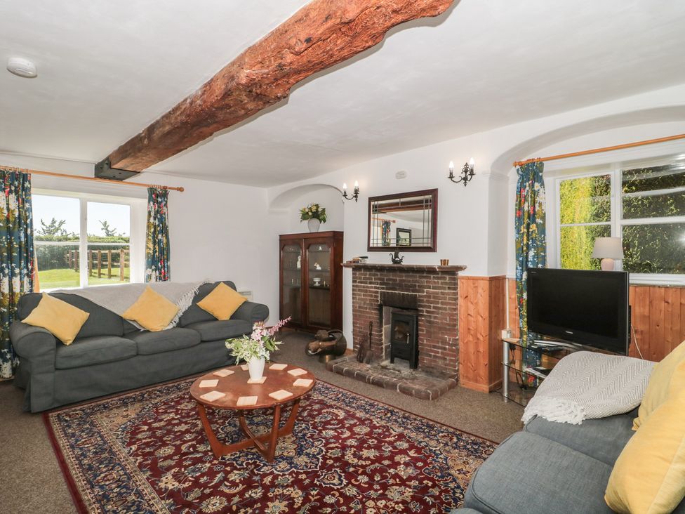 A living room with a fireplace and a sofa at Walk Farmhouse in Gloucester