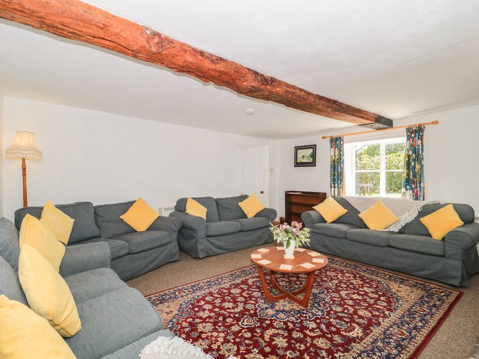 A living room with sofas and a lamp at Walk Farmhouse in Gloucester