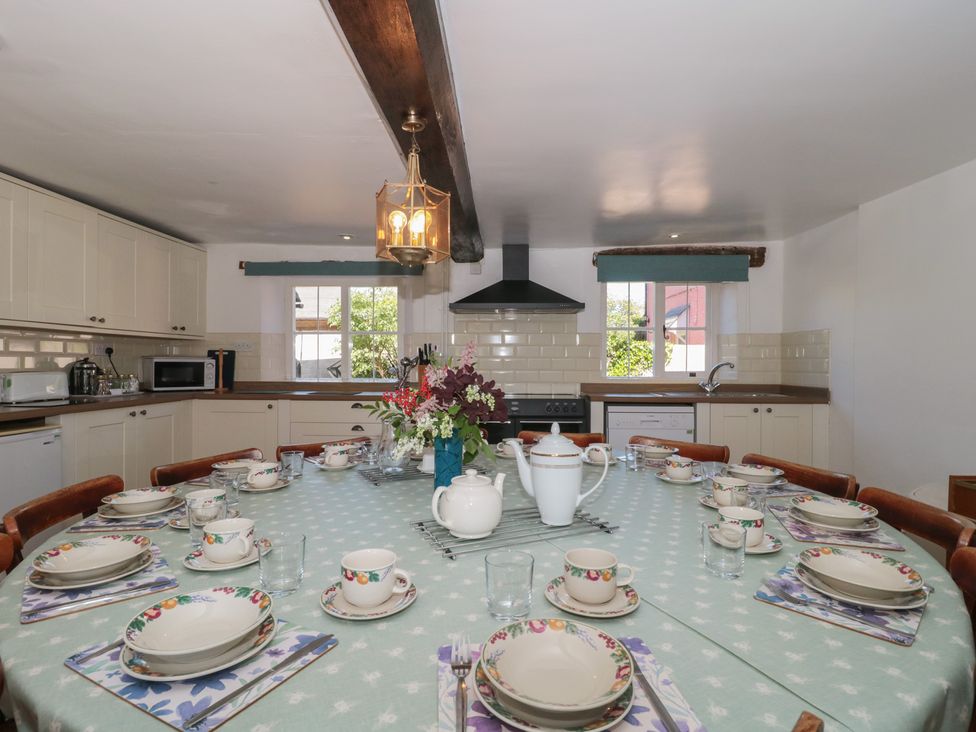 A kitchen with a large dining table set up at Walk Farmhouse in Gloucester