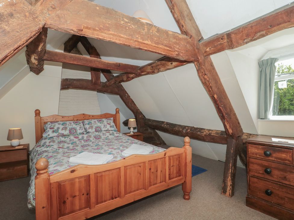 A bedroom with a bed and wooden beams at Walk Farmhouse in Gloucester