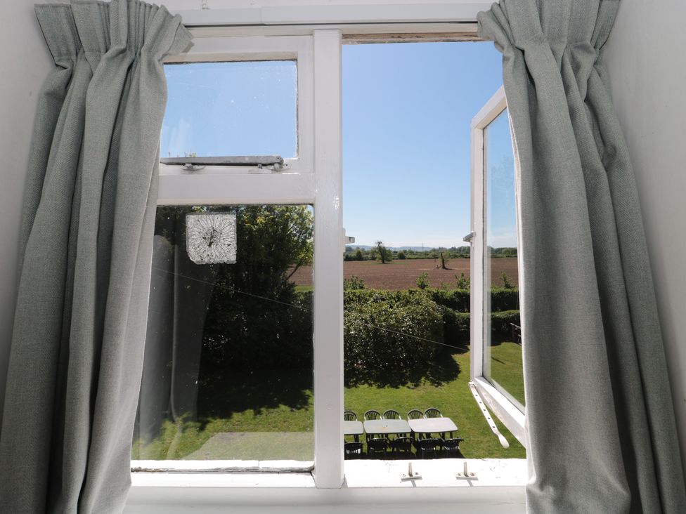 A view from a window showing a garden with table and chairs at Walk Farmhouse in Gloucester