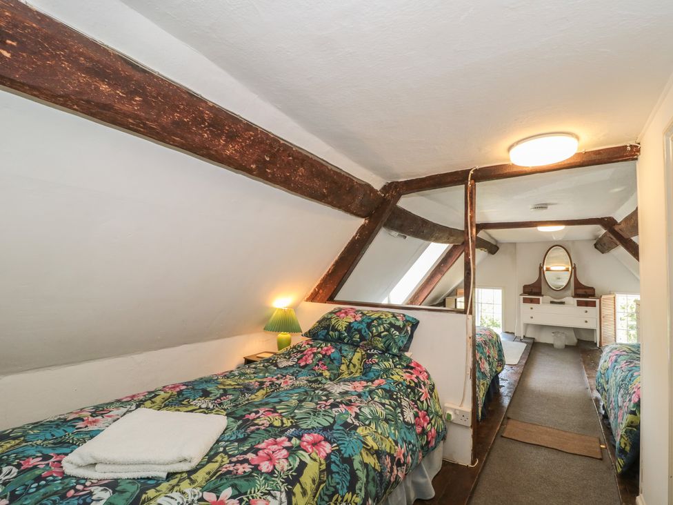 A bedroom with two beds and a dressing table at Walk Farmhouse in Gloucester