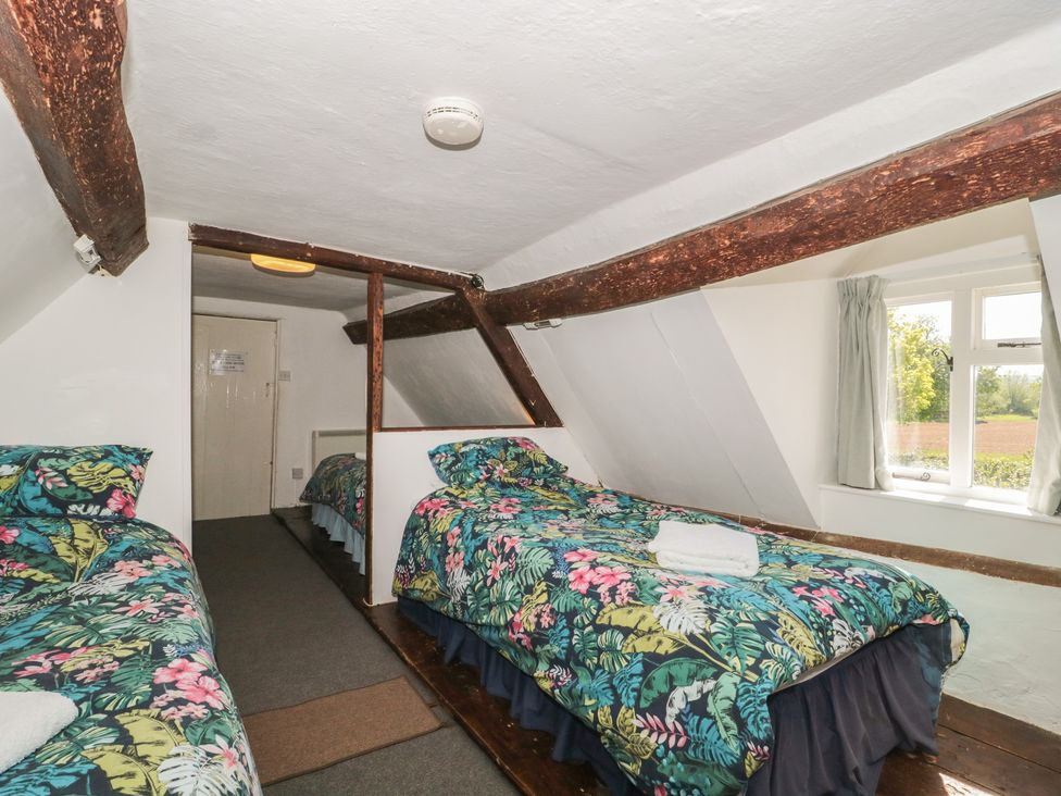 A bedroom with two beds and a window at Walk Farmhouse in Gloucester
