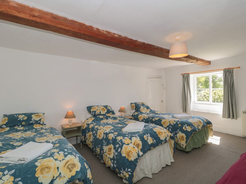 A bedroom with three beds and a window at Walk Farmhouse in Gloucester