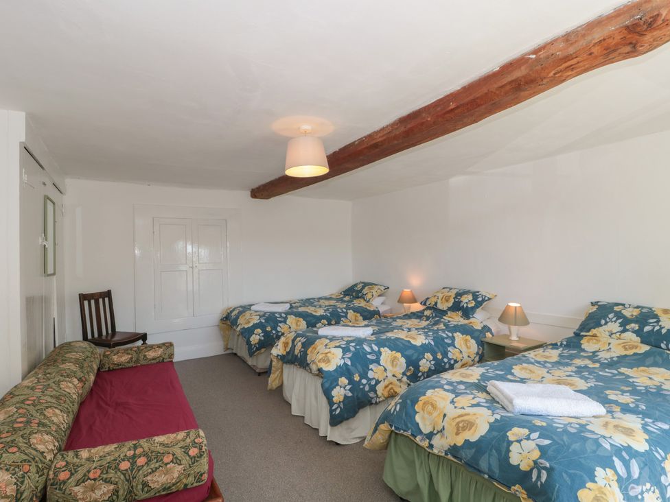 A bedroom with three beds and a sofa at Walk Farmhouse in Gloucester