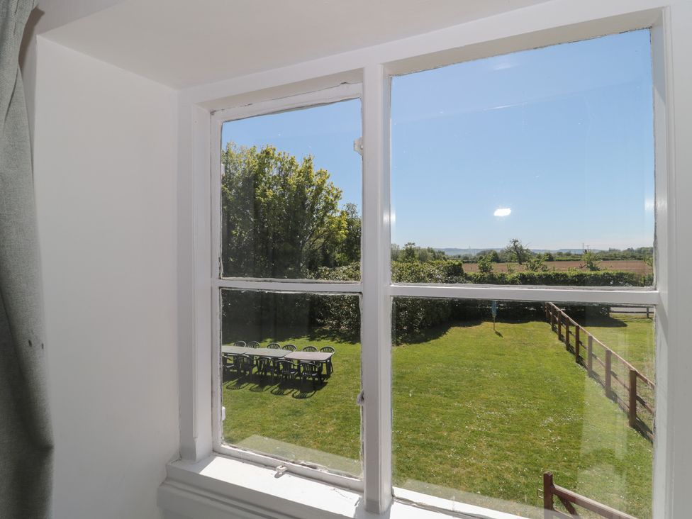 A view from a window showing a garden with table and chairs at Walk Farmhouse in Gloucester