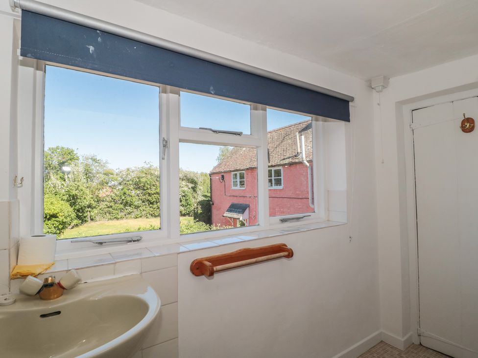 A bathroom with a sink and window at Walk Farmhouse in Gloucester