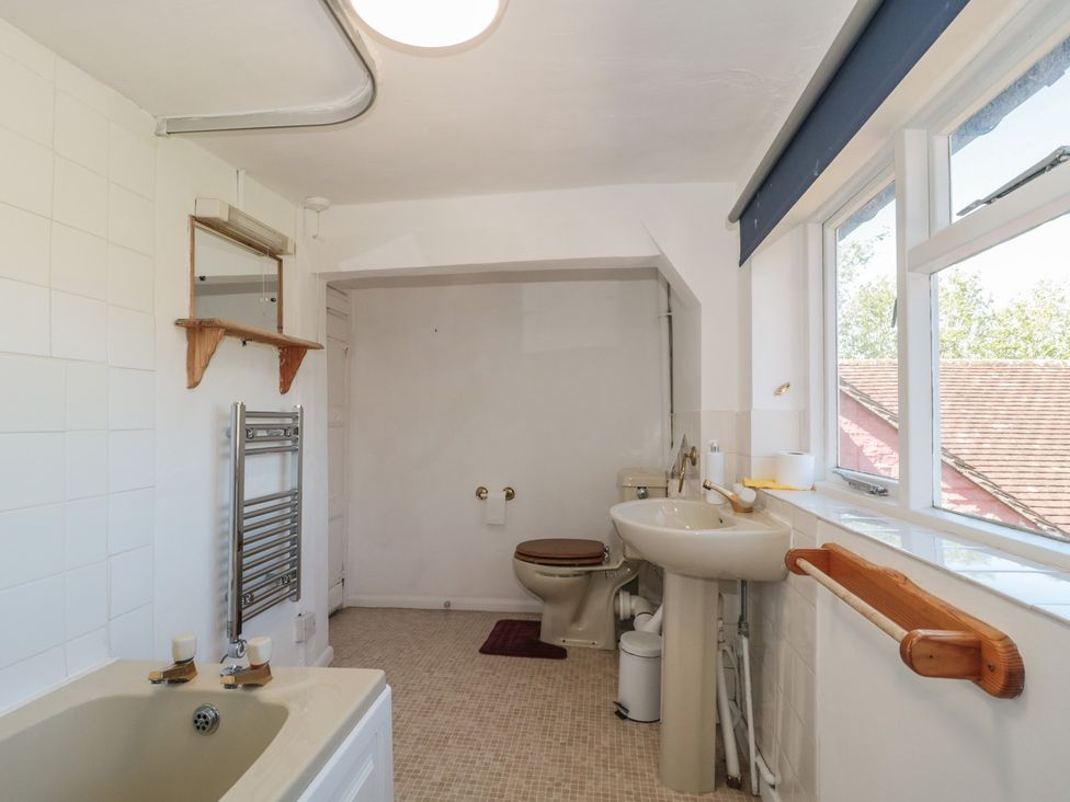 A bathroom with a bathtub, toilet, and sink at Walk Farmhouse in Gloucester