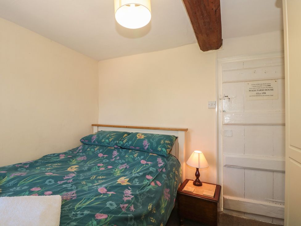 A bedroom with a bed and bedside table at Walk Farmhouse in Gloucester