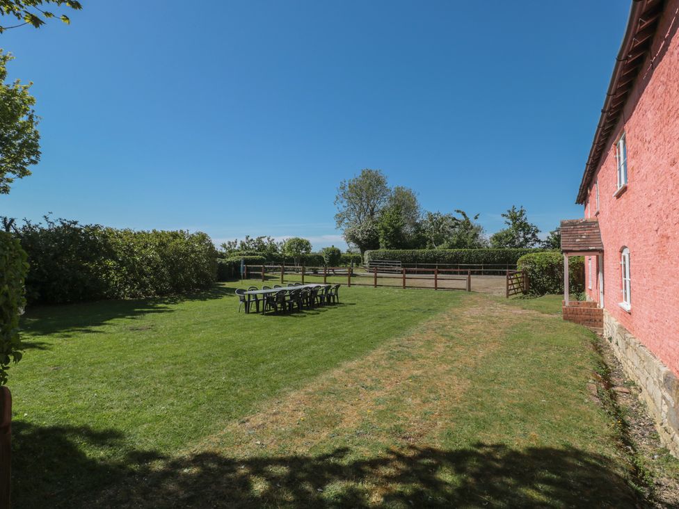 A garden with chairs and trees at Walk Farmhouse in Gloucester