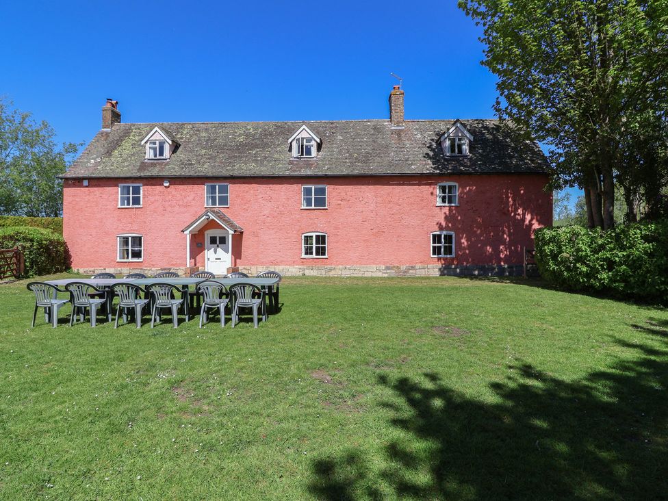 A house with chairs arranged on the lawn at Walk Farmhouse in Gloucester