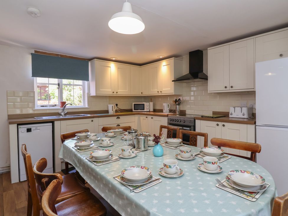 A kitchen with dining table and appliances at Walk House in Gloucester
