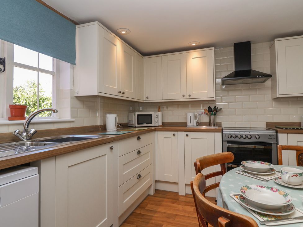 A kitchen with a sink, stove, and dining table at Walk House in Gloucester