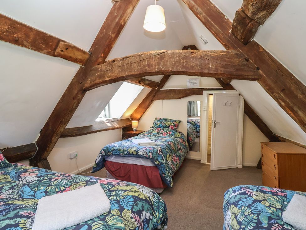 A bedroom with two beds and a wardrobe at Walk House in Gloucester