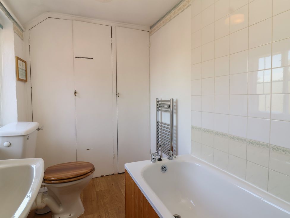 A bathroom with a bathtub, toilet, and a towel radiator at Walk House in Gloucester