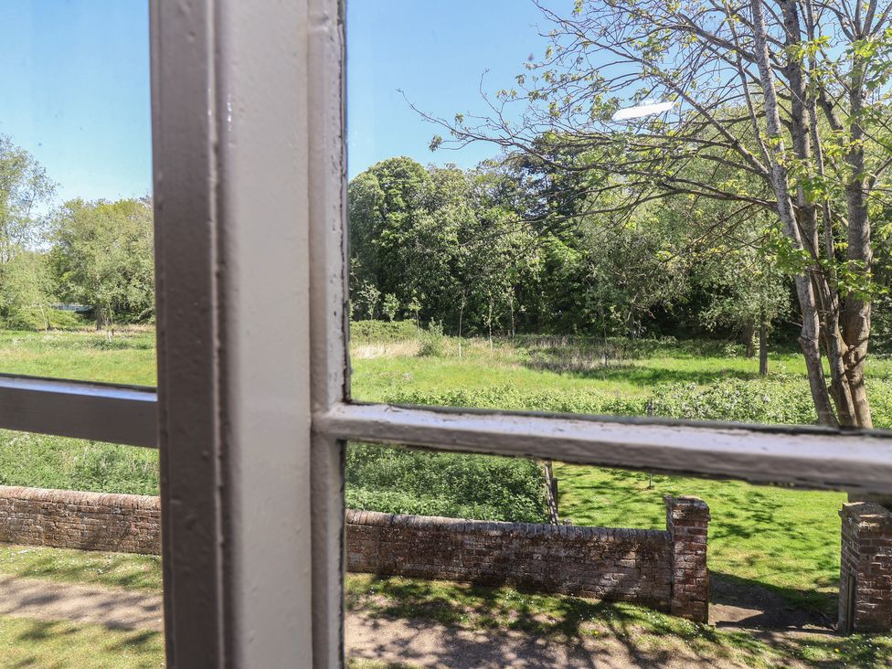 A view of a garden with trees and grass at Walk House in Gloucester