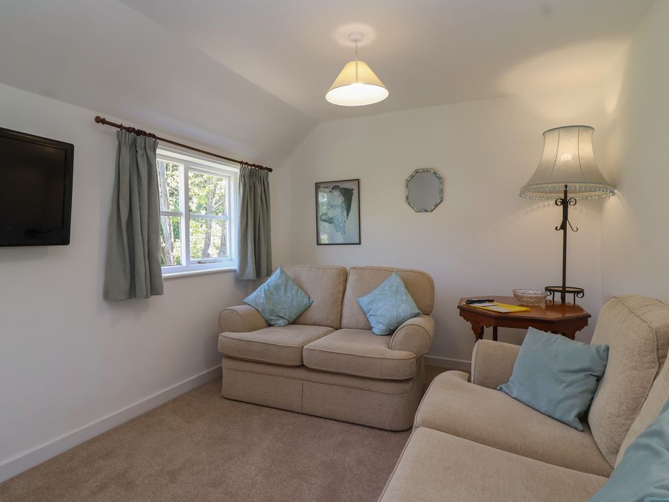 A living room with a sofa and television at Walk Farm Cottage in Gloucester