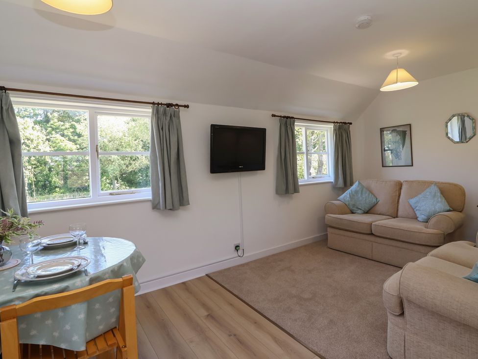 A living room with a sofa and table at Walk Farm Cottage in Gloucester