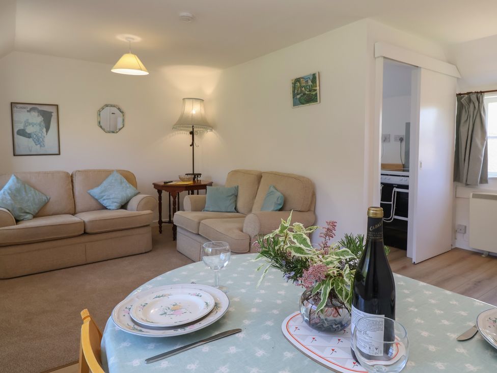 A living room with a sofa and dining table at Walk Farm Cottage in Gloucester