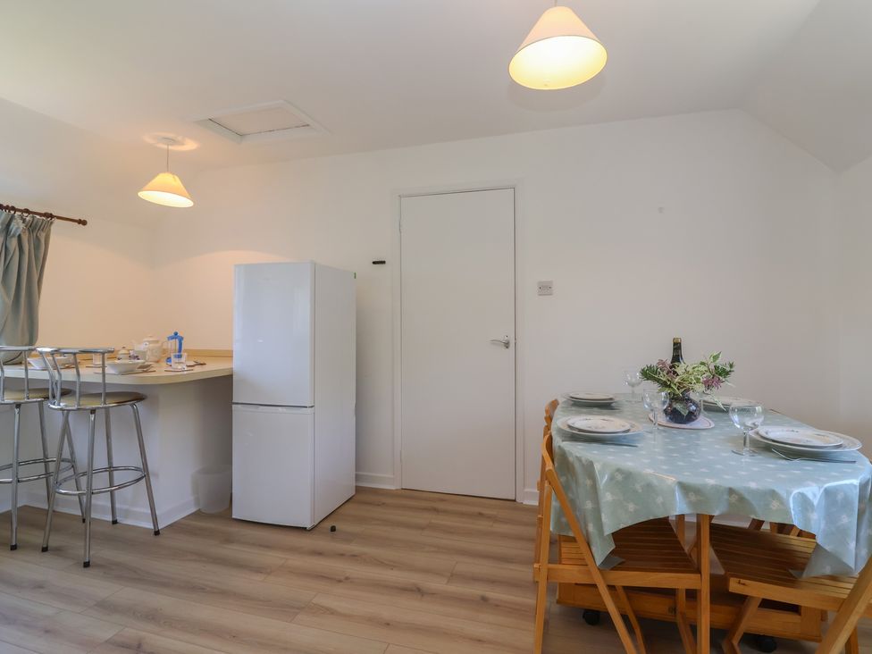 A kitchen with a table and chairs at Walk Farm Cottage in Gloucester