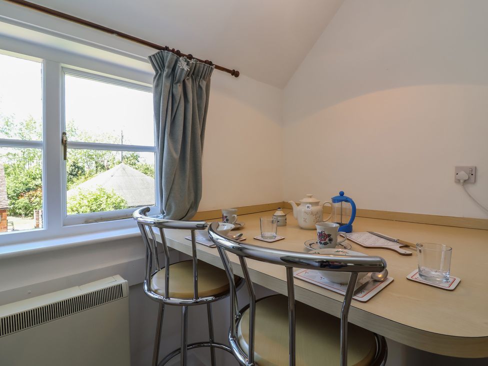 A kitchen with a table and chairs at Walk Farm Cottage in Gloucester