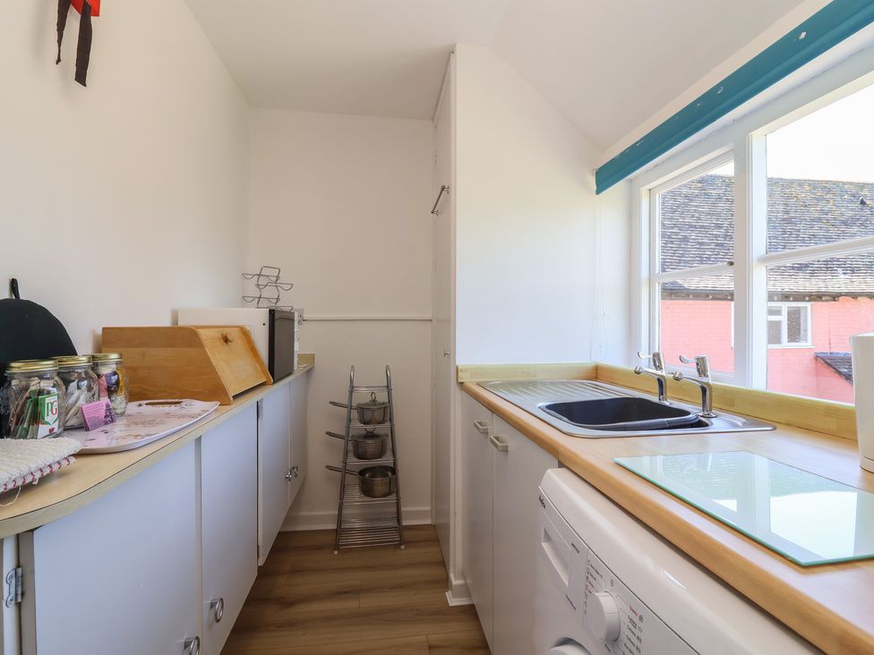 A kitchen with a sink and washing machine at Walk Farm Cottage in Gloucester