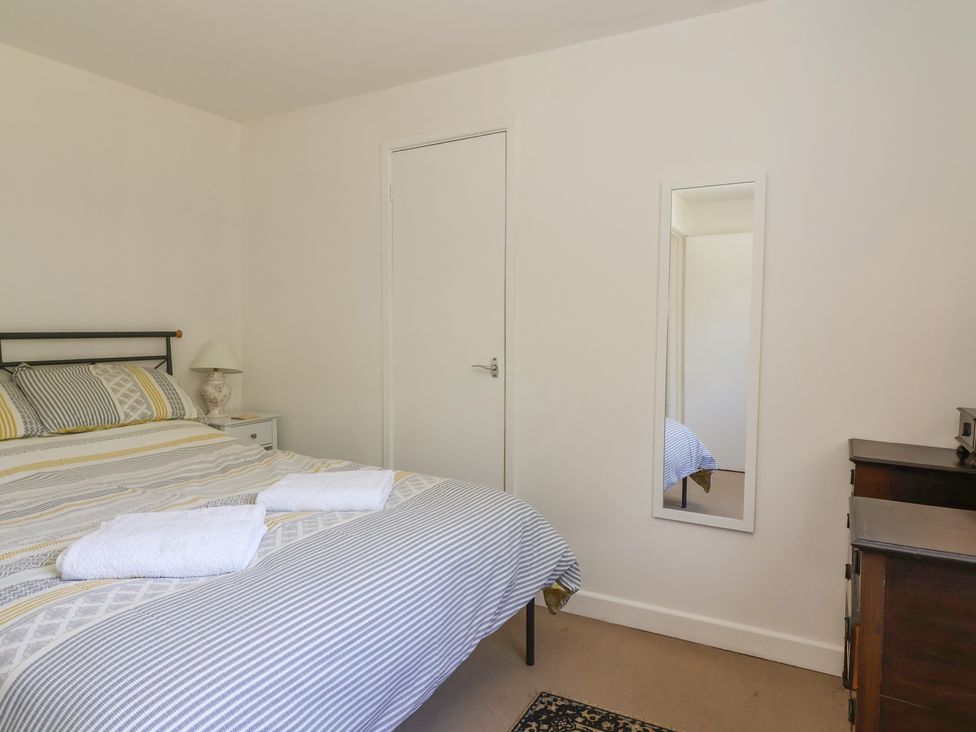 A bedroom with a bed and bedside lamp at Walk Farm Cottage in Gloucester
