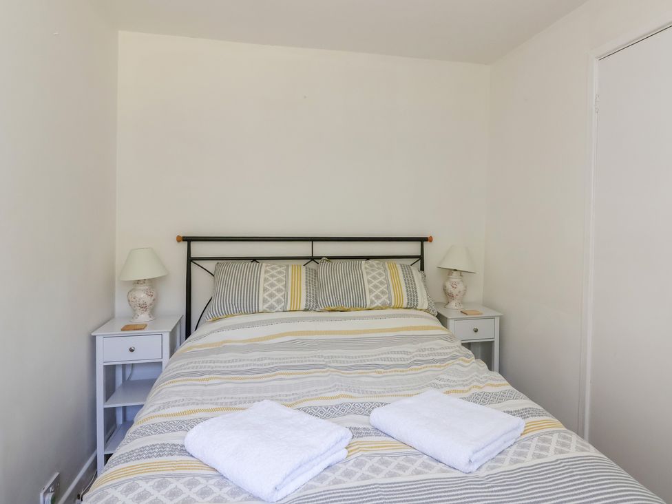 A bedroom with a bed and nightstands at Walk Farm Cottage in Gloucester