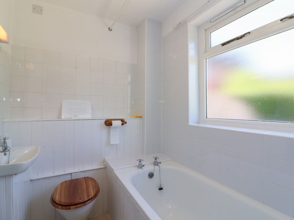 A bathroom with a bathtub, toilet, and sink at Walk Farm Cottage in Gloucester