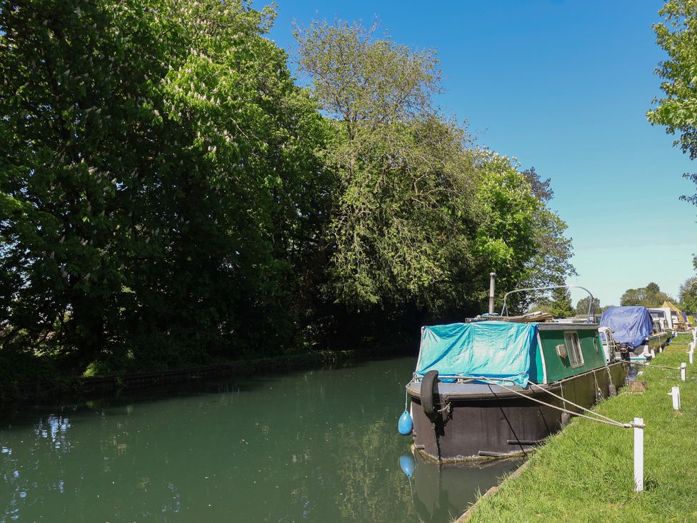 A narrowboat on a canal surrounded by trees at Walk Farm Cottage in Gloucester