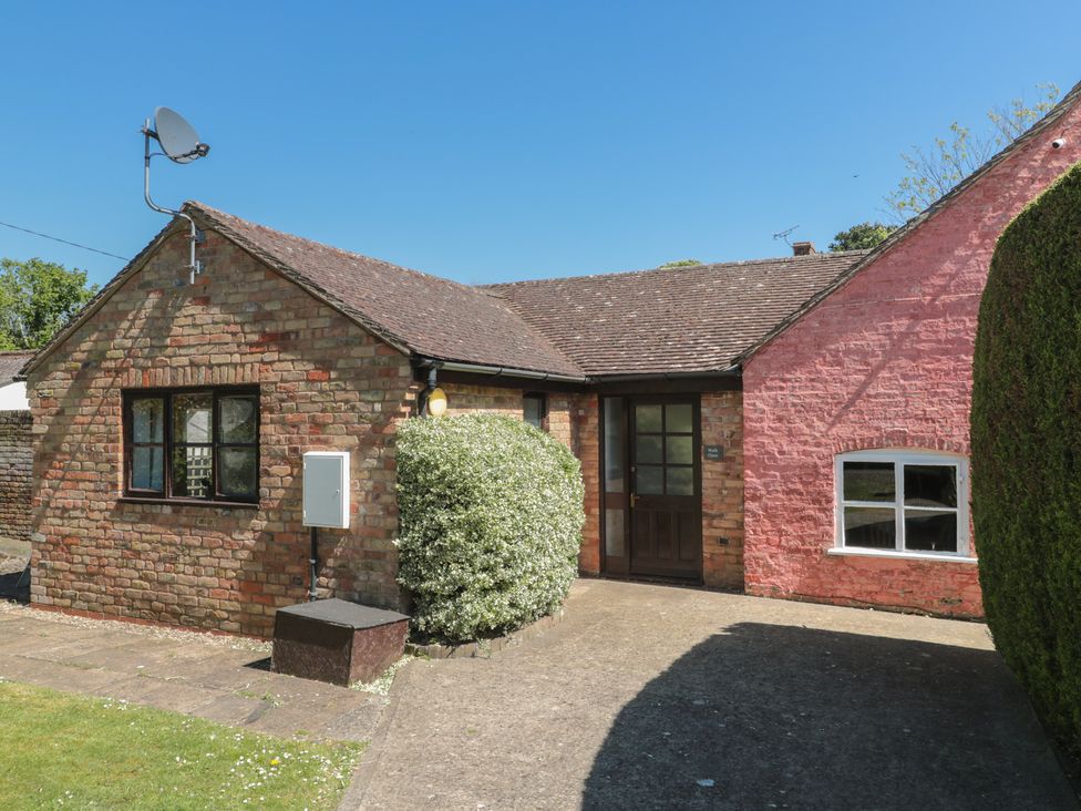 A house with a brick facade and garden features at Walk Close in Gloucester