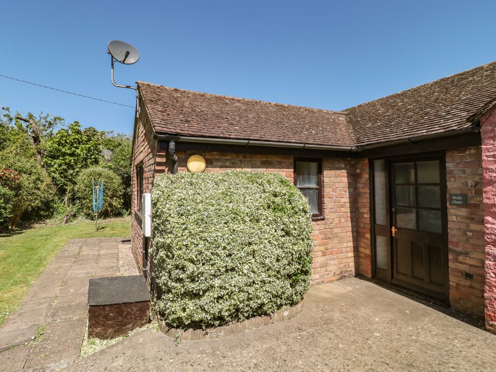 An exterior view of a house with a bush and satellite dish at Walk Close, Gloucester