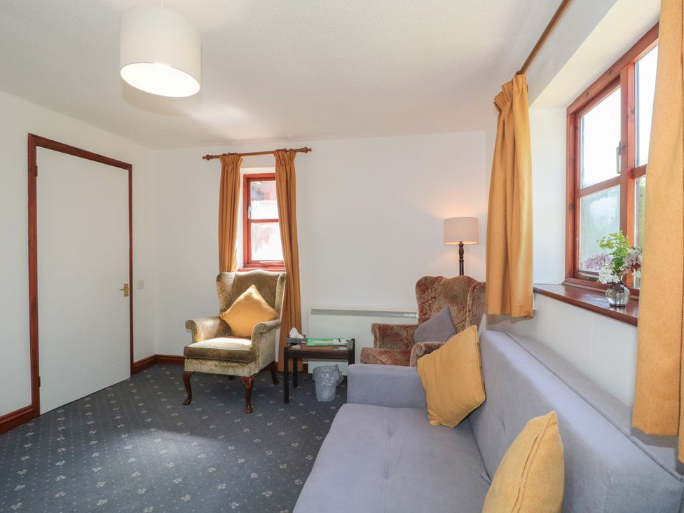 A living room with a sofa and armchair at Walk Close in Gloucester